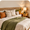 Quarto de casal claro com cama de madeira, manta verde, almofadas terracota e abajur aceso